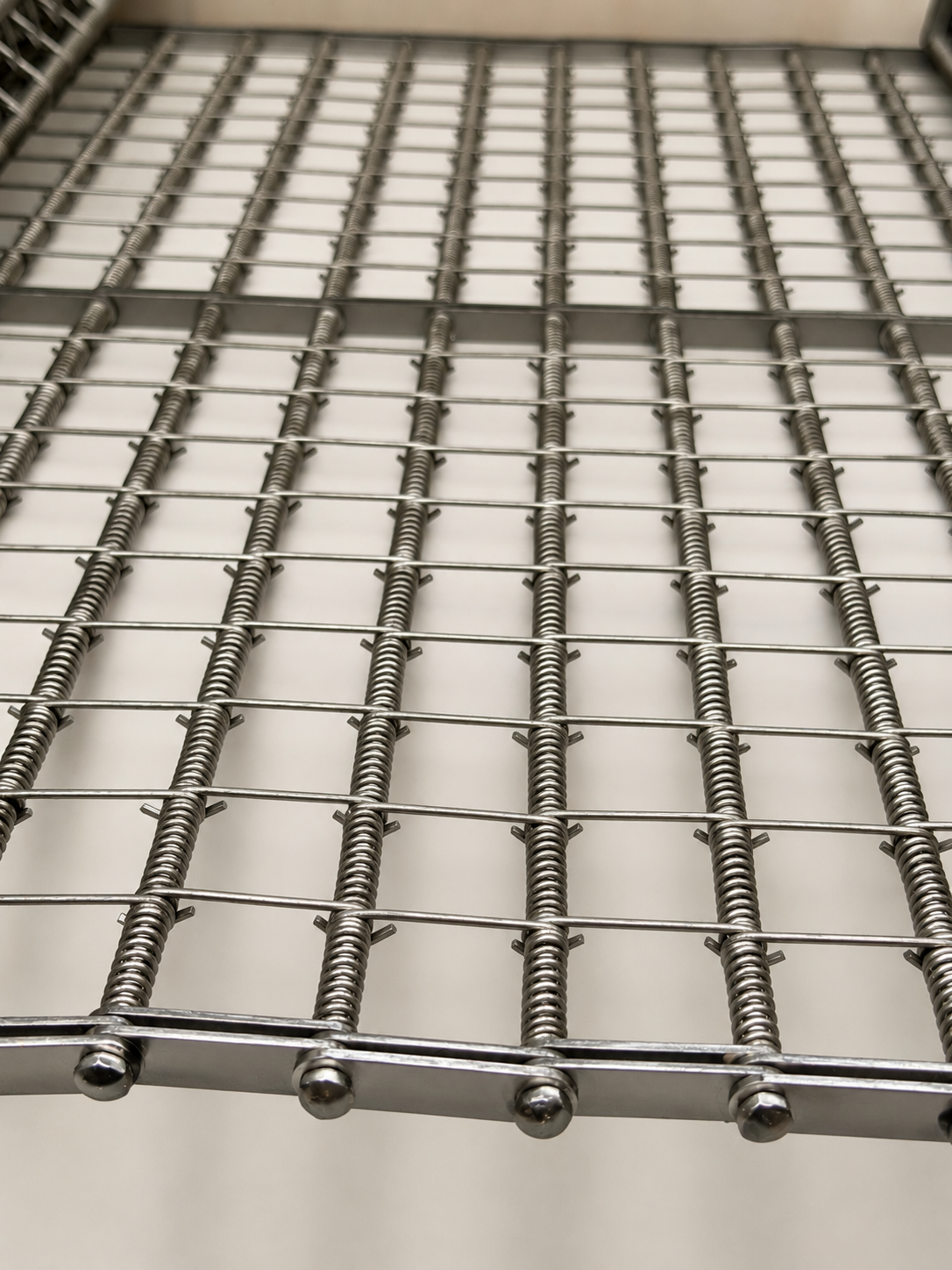 Open grid wire conveyor belt with button rod edge